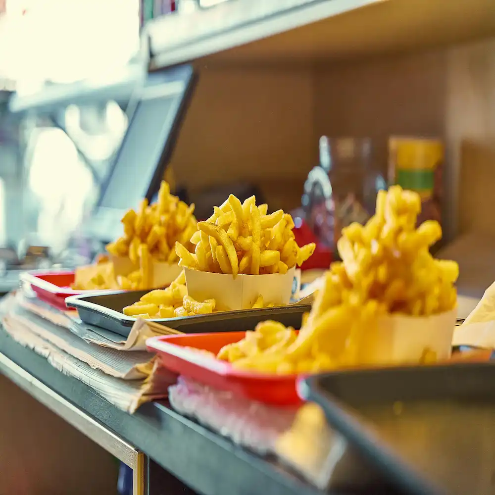 An image of fries in trays that are about to be served.